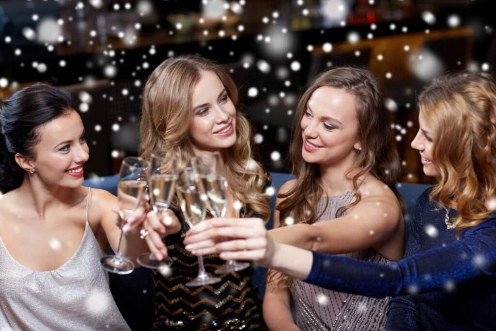 A group of women toasting with champagne glasses in a nightclub, celebrating their night out with Cincinnati DJ music.