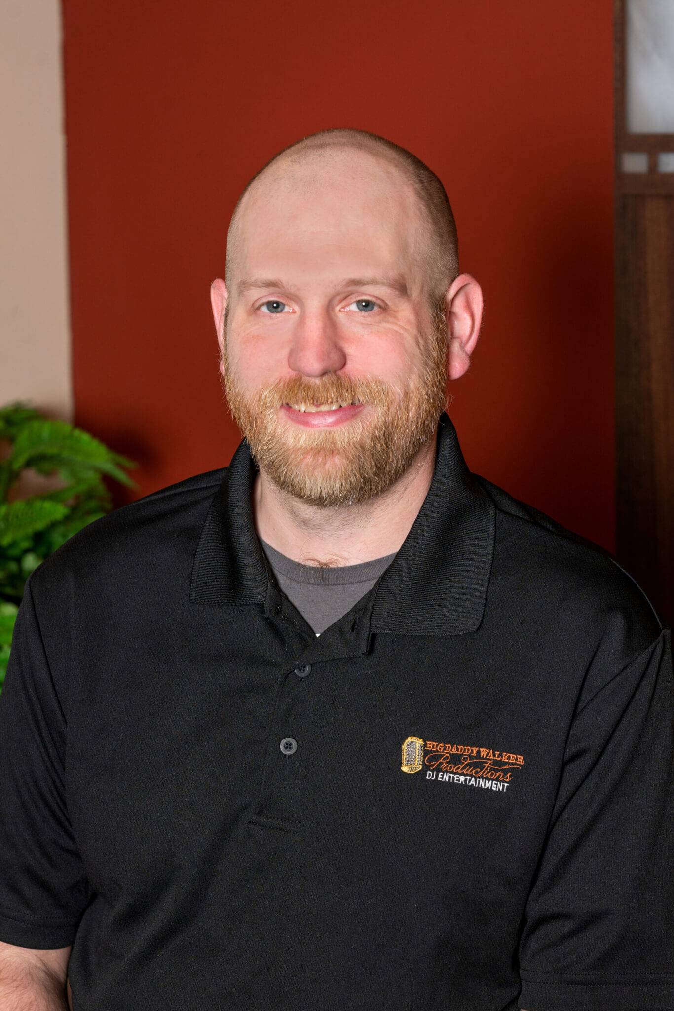 A bald man in a black polo shirt providing wedding DJ services in Cincinnati, Ohio.