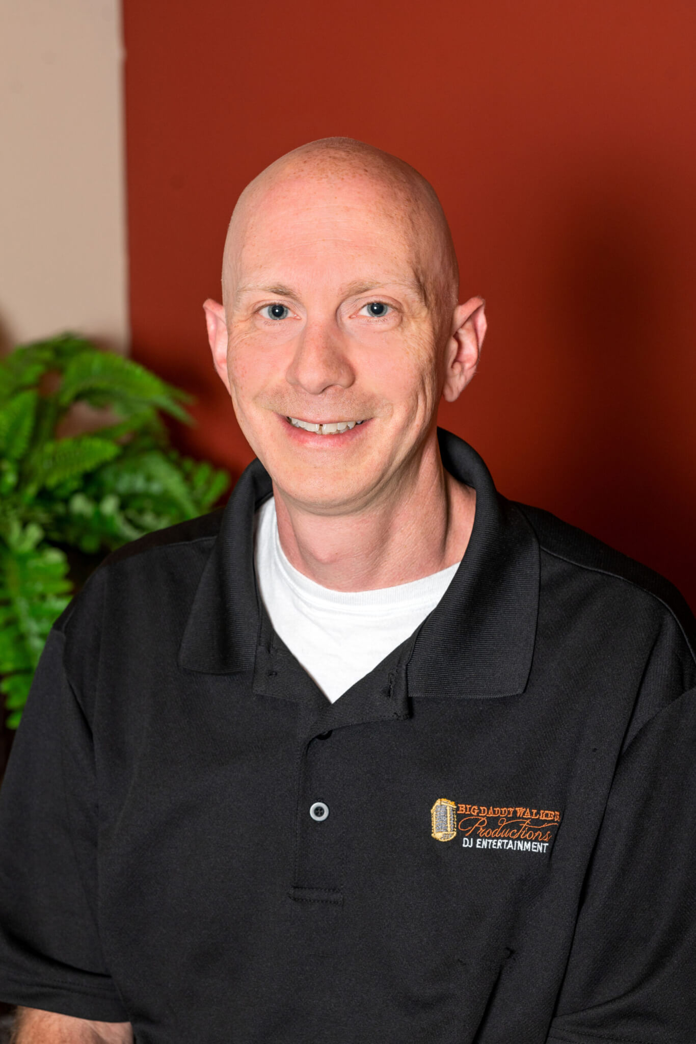 A bald man in a black shirt, serving as a Cincinnati DJ for weddings in the area.