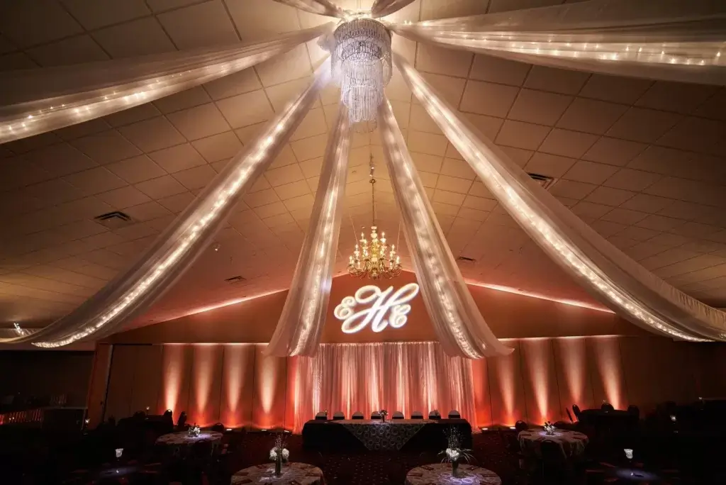 The Woodlands wedding reception with a chandelier, draper and a monogram 